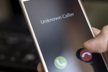 Unknown caller. A man holds a phone in his hand and thinks to end the call. Incoming from an unknown number. Incognito or anonymous