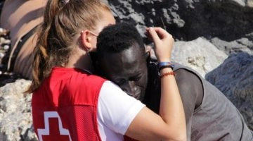 La foto di un abbraccio che ha fatto il giro del mondo, quello tra la giovane volontaria della Croce...